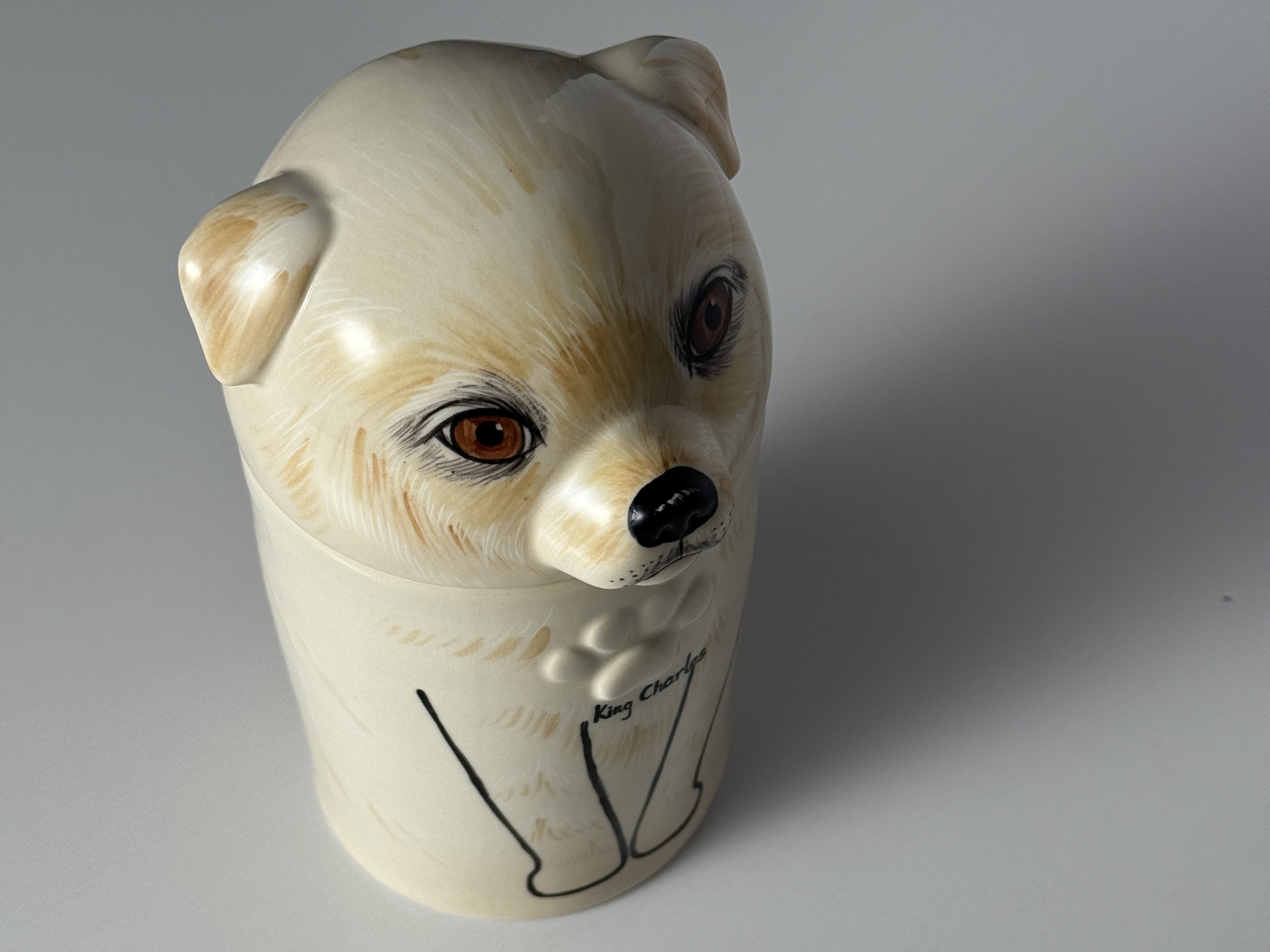 Ceramic mug shaped like a dog's head on a plain background