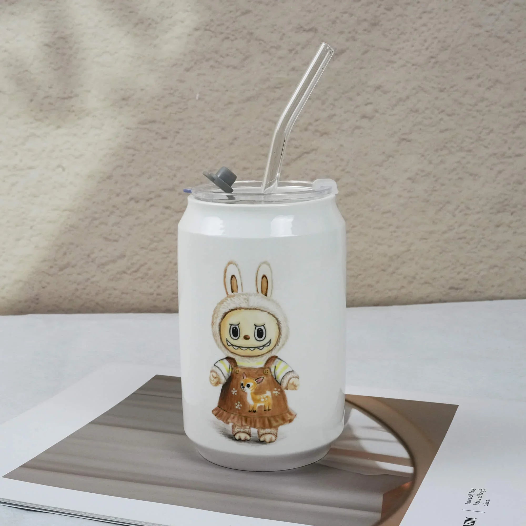 White tumbler with a cartoon character on a textured surface
