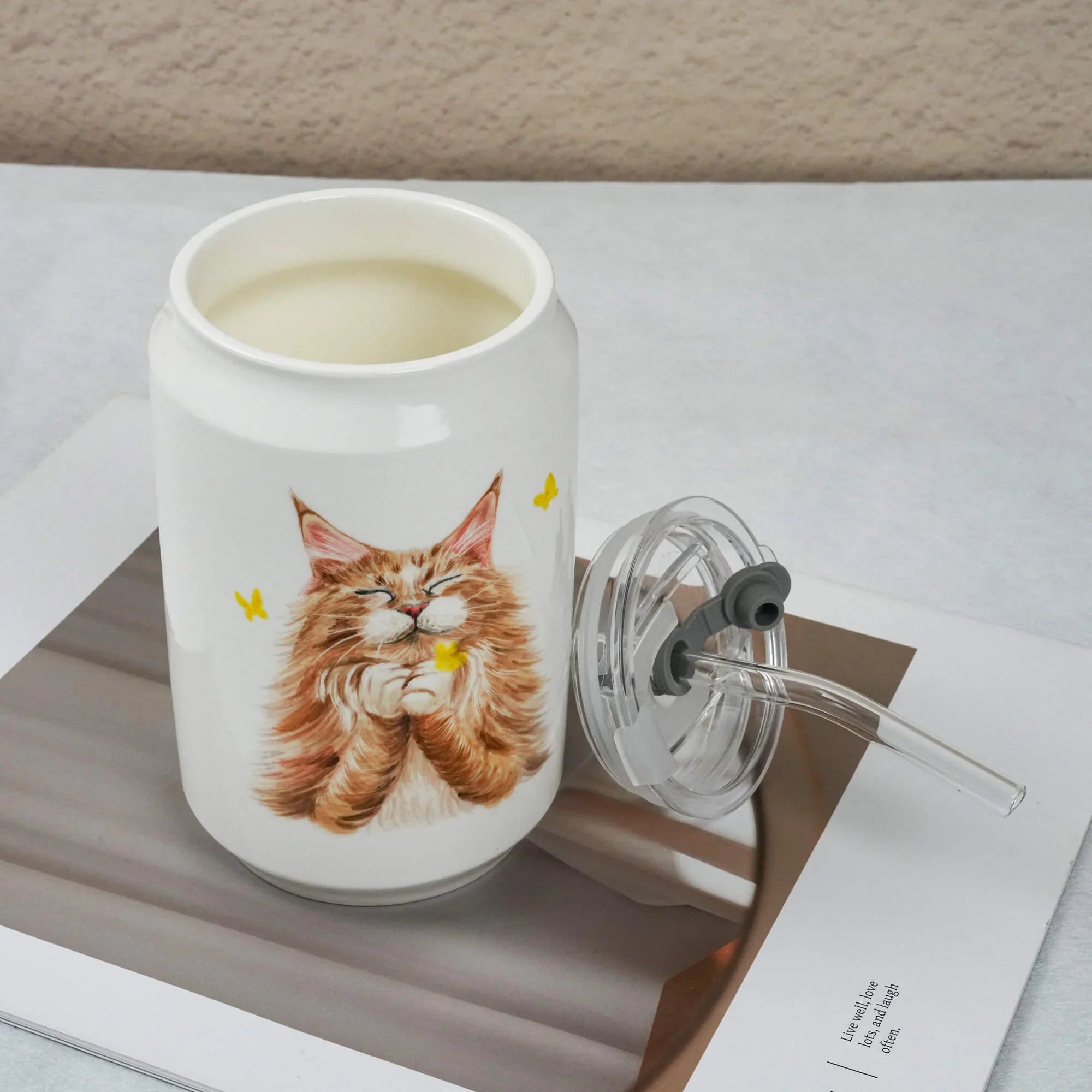 White tumbler with a cat illustration on a white surface