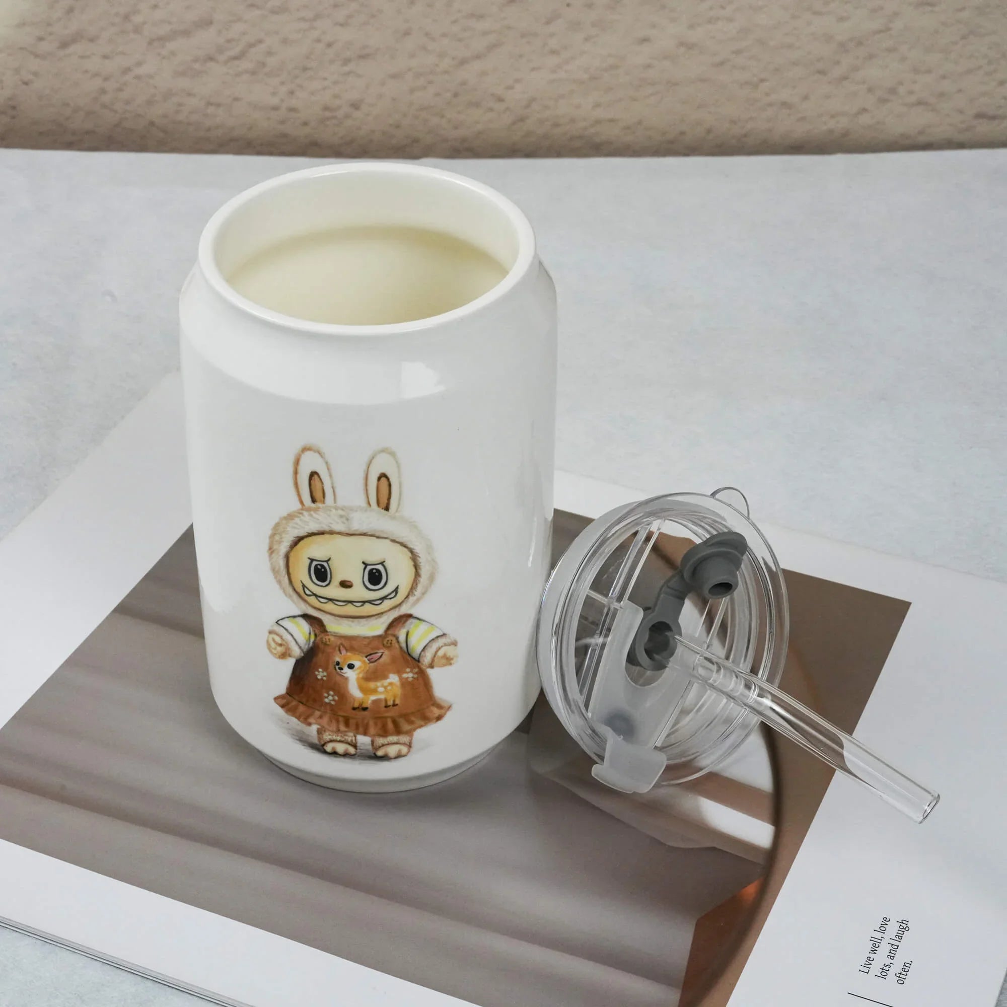 White mug with a cartoon character design on a white surface